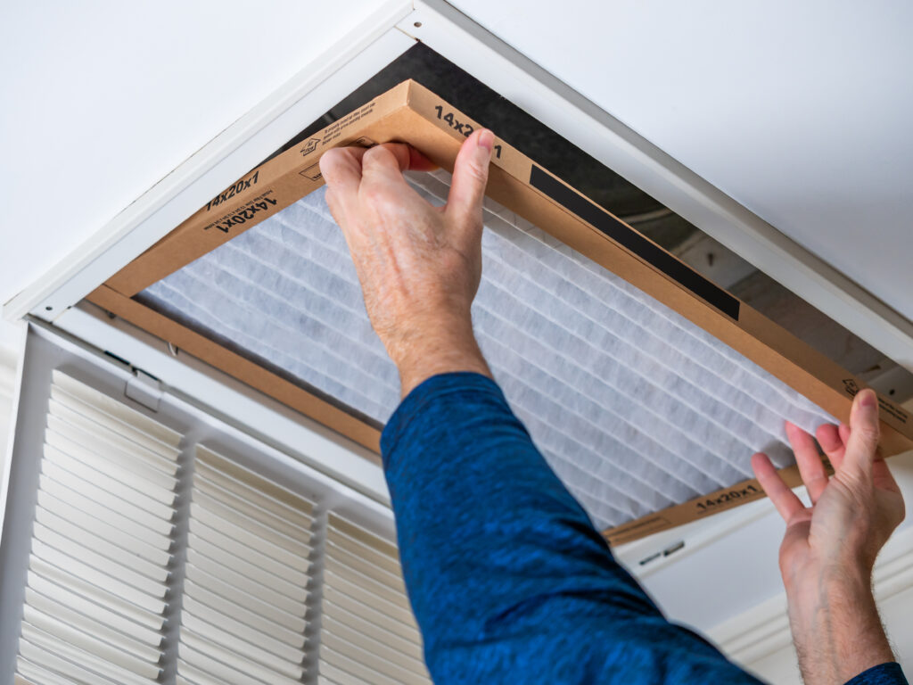 HVAC technician replacing a home air filter in Goleta