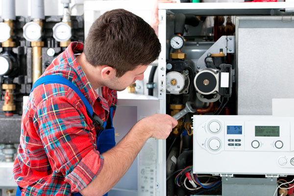 Heating technician repairing boiler controls in Goleta