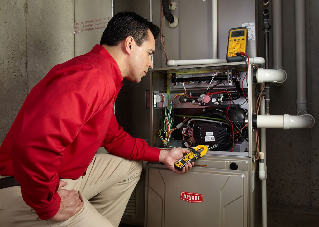 Heating technician diagnosing a furnace repair in Goleta