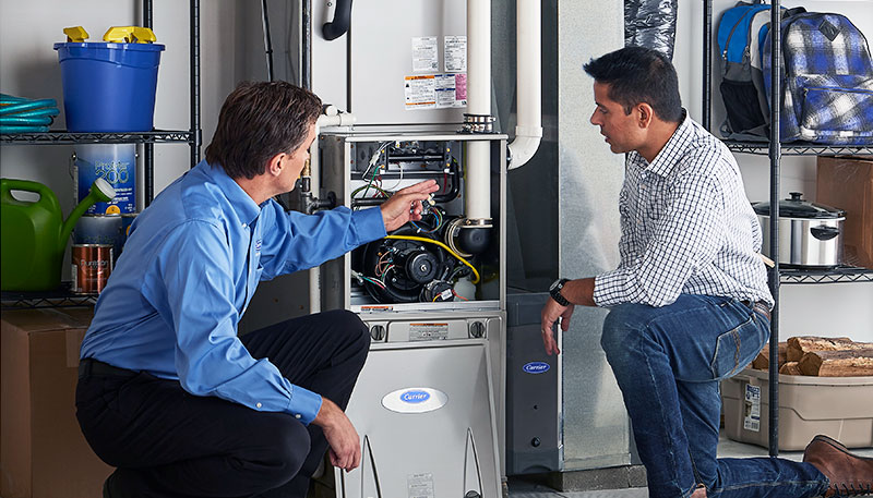 Technician evaluating a furnace for repair or replacement in Goleta