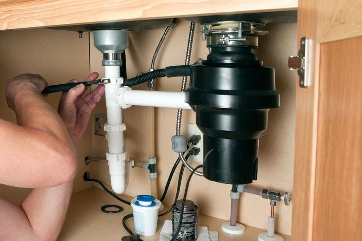 Plumber repairing a garbage disposal in Goleta