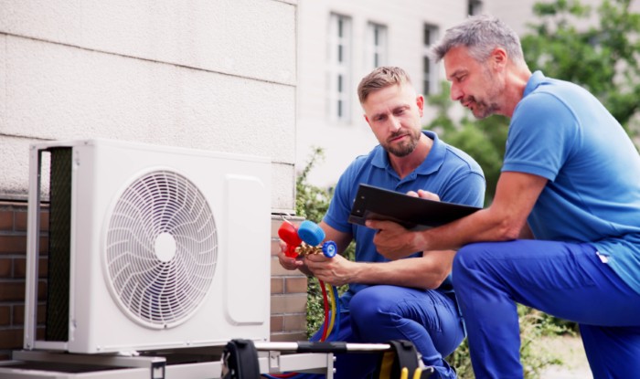 HVAC technicians installing an outdoor air conditioning unit in Goleta