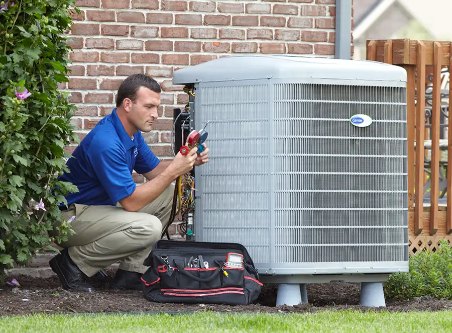 HVAC technician inspecting an outdoor AC unit in Goleta